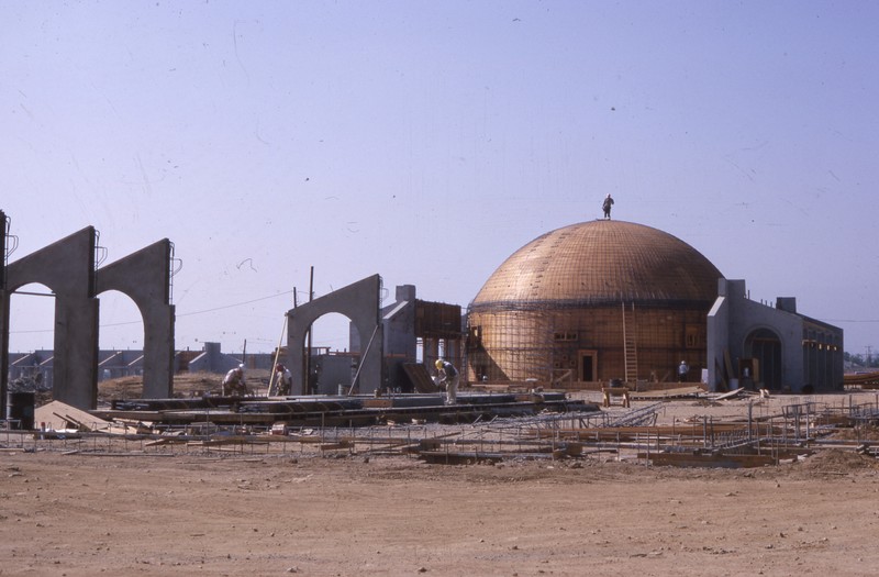 The planetarium dome at De Anza college is under construction in 1966. Archways, with no buildings yet attached, are springing up all over the campus. 