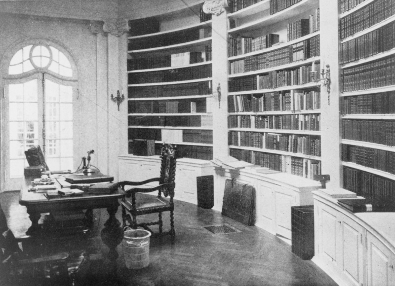 The stately library of Le Petit Trianon includes curved bookcases, a custom oak floor and beautiful hand crafted doors and windows. Photographer and date of photo unknown.