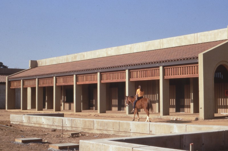 A local resident rides her horse through the L Quad area as De Anza College is being built. When this photo was taken (1966 or 1967) the area surrounding the college was mostly agricultural. Photo by Pat Bresnan, faculty, De Anza College.