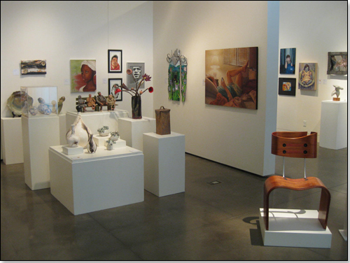 Multiple small sculptures on pedestals, multiple paintings on walls.