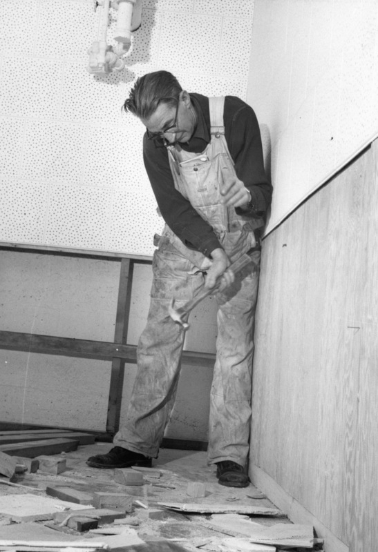 Unidentified man hammering wall during construction of KFJC radio studio in basement of Foothill College, 1959. 