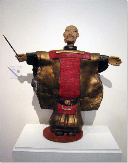 Warrior sculpture with hands outstretched to sides, holding a baton.