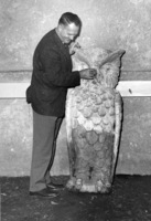 Calvin Flint pretends to "tweek" the nose of Footsie, the owl that is Foothill's mascot. The stone owl came from Foothill's temporary location in Mountain View, where this picture was taken in 1959. The owl was moved to the campus in Los Altos Hills in 1961, where it remains to this day,  mounted on a wall inside the main dining room.