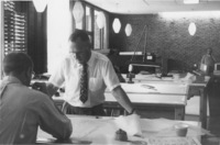 Calvin Flint, Foothill College's first President, later the first District Superintendent, reviews blue prints for the award winning design of Foothill College. Earnest J. Kump, chief architect, sits with his back to the camera.