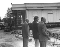 Three men observe the progress as Le Petite Trianon is being moved to a new location. On the right, closest to the camera, is Dr. Robert Smithwick, the District's first Board Chairperson. In the center is Dr. A. Robert DeHart, De Anza's first President. The man on the left has not been identified. Image taken in the late 1960s.
