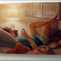 Person relaxing on bed, viewing cell phone, illuminated by lamp.