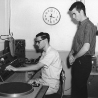 Two students working at the KFJC broadcast desk in the basement of Foothill College in Mountain View in a photo from 1960.