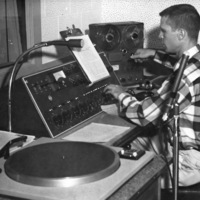 Bob Ballou, station manager, sits at the radio controls and speaks the first official words on KFJC in this photo from the October 23, 1959 edition of the Foothill Sentinel. 