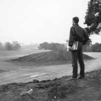 A Foothill College student watches from atop a hill as the campus begins to take shape.