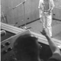 Bob Ballou at the microphone in the recording room with an unidentified student at the control booth in the basement of Foothill College in Mountain View. 