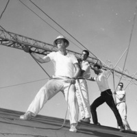 Four men raising the KFJC radio antenna on the roof of the Foothill College building in Mountain View. Pictured from left to right are Bob Ballou, Jim Fernbaugh, Nathan Ballard and Roger Murray. Photographer Gary Pagano for the Foothill Sentinel, October 9, 1959.