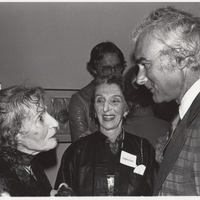 Two artists converse with a male reception guest.