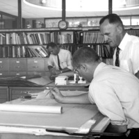 Dr. Calvin C. Flint reviews architectural drawings of Foothill College in the offices of Ernest P. Kump in Palo Alto, California. 