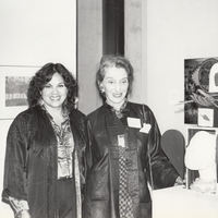 Two artists at reception near artwork.