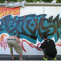 Two activist students spray painting a mural that says 'Activism.'