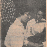 Photograph of KFJC announcer Jacqueline Nichols at the station microphone as Fred Kulick and Bruce Wentler look on.