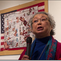 Flo Oy Wong speaking in front of one of her artworks.