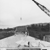 Workers place the iconic "hat" on top of a Foothill building during construction in 1960.
