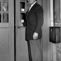 Calvin Flint stands at the rear entrance to the first meeting space for the Board of Trustees, located in a small building in downtown Los Altos. The Board continued to meet in this space from 1958 until 1961, when the new Foothill campus opened in Los Altos Hills.
